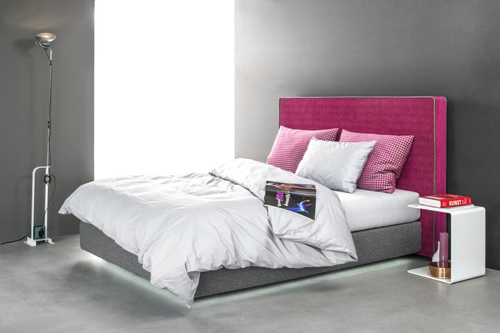 Boxspringbett mit Stoffbezug in grau und Kopfteil in pink strukturiert mit grauer Kederverarbeitung