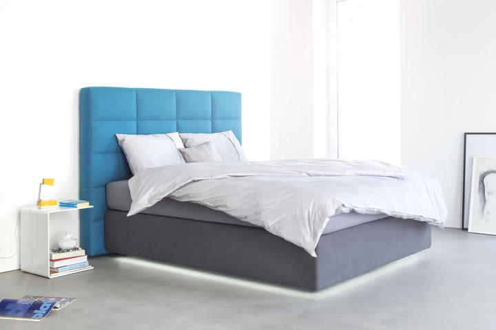 Boxspringbett mit Stoffbezug in grau und gestepptem Kopfteil in blau